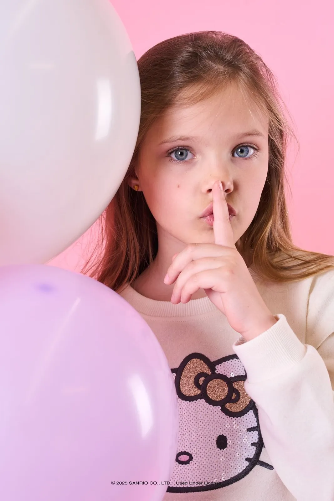 Girl in a Hello Kitty top with balloons